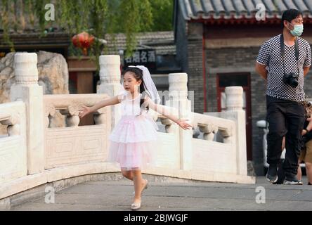 Pékin, Chine. 30 avril 2020. Une jeune fille chinoise danse sur un pont, le gouvernement ayant déclaré la menace de l'épidémie de Covid-19 s'est terminée à Pékin le jeudi 30 avril 2020. La capitale chinoise a abaissé aujourd'hui sa réponse d'urgence à la nouvelle pandémie de coronavirus, du niveau supérieur au deuxième niveau, le "dernier signe de restauration de l'ordre social à mesure que les conditions épidémiques ont été assouplies", selon les médias d'État. Photo de Stephen Shaver/UPI crédit: UPI/Alay Live News Banque D'Images