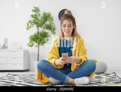 Jeune femme dans un gilet jaune à l'intérieur du smartphone Banque D'Images