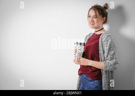 Jeune femme dans un gilet chaud sur fond clair Banque D'Images