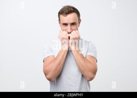 Des prix ridiculement bizarres. Homme caucasien gai riant et couvrant la bouche avec la paume, regarder la comédie ou entendre la plaisanterie drôle. Studio tourné Banque D'Images
