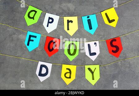 Drapeaux colorés avec phrase « avril Fool's day » sur fond gris Banque D'Images