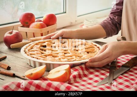 Femme avec tarte aux pommes américaine à la table Banque D'Images