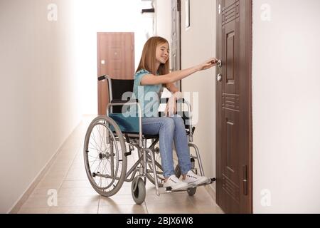 Une adolescente en fauteuil roulant dans le couloir scolaire Banque D'Images