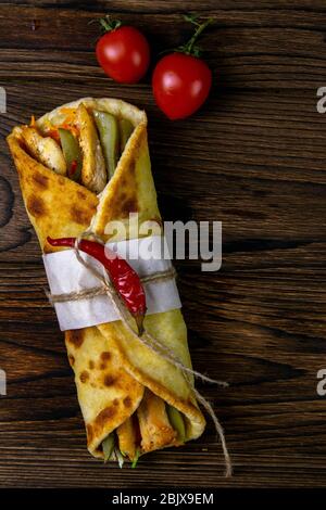 Beer wrap kebab. Le shawarma avec de la viande, des oignons, de la salade se trouve sur une vieille table en bois sombre. Vues de dessus avec espace libre Banque D'Images