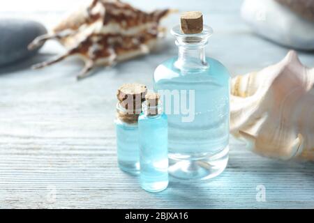 Bouteilles avec huile de parfum sur table en bois Banque D'Images