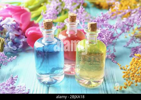 Bouteilles avec différentes huiles de parfum sur table en bois Banque D'Images