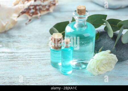 Bouteilles avec huile de parfum sur table en bois Banque D'Images