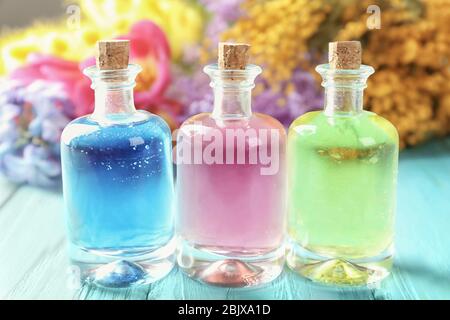 Bouteilles avec différentes huiles de parfum sur table en bois Banque D'Images