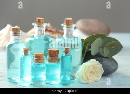 Bouteilles avec huile de parfum sur table en bois Banque D'Images