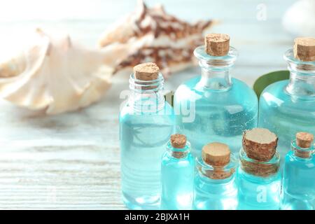 Bouteilles avec huile de parfum sur table en bois Banque D'Images