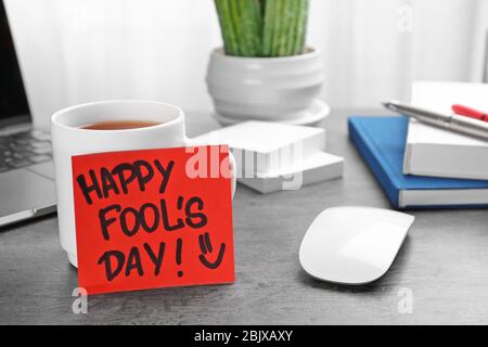 Notez avec l'expression « Happy Fool's day » sur la table de bureau. Célébration du 1 avril Banque D'Images