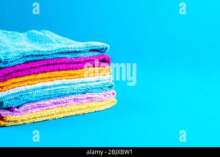 Serviettes multicolores sur fond bleu. Serviettes de toilette roses, beiges, jaunes et bleues. Lieu d'écriture. Ordre de maison Banque D'Images