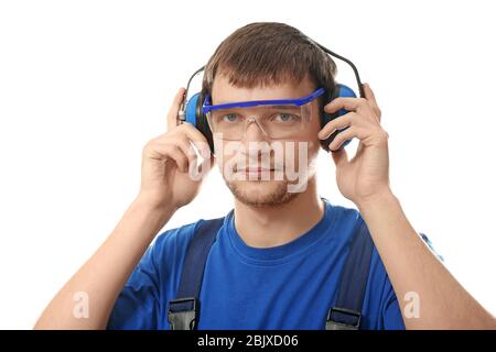 Travailleur masculin avec casque sur fond blanc. Équipement de protection auditive Banque D'Images