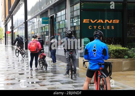 File d'attente en dehors des cycles Evans, l'un des magasins essentiels a permis de rester ouvert pendant la pandémie de coronavirus pour un entretien urgent et cliquez et collectez. Banque D'Images