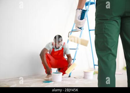Décorateurs d'hommes faisant réparer dans la chambre Banque D'Images