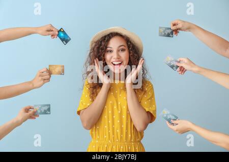 Jeune femme afro-américaine et les mains avec des cartes de crédit sur un fond de couleur Banque D'Images