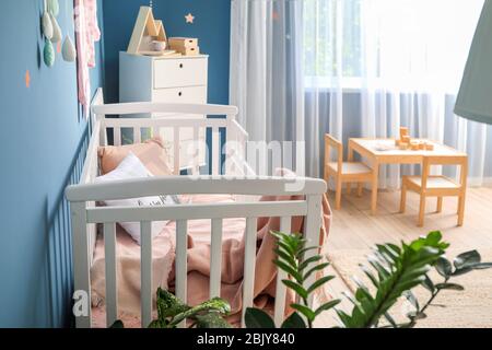 Lit bébé dans un intérieur moderne de la chambre des enfants Banque D'Images