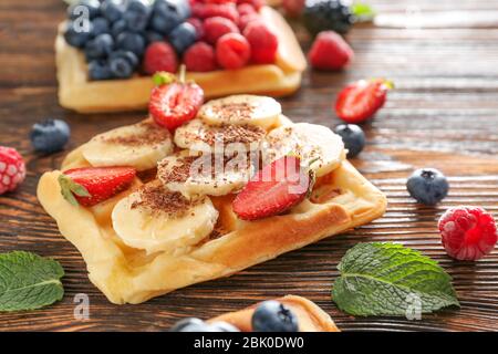 Gaufres sucrées savoureux avec des fruits sur la table en bois Banque D'Images