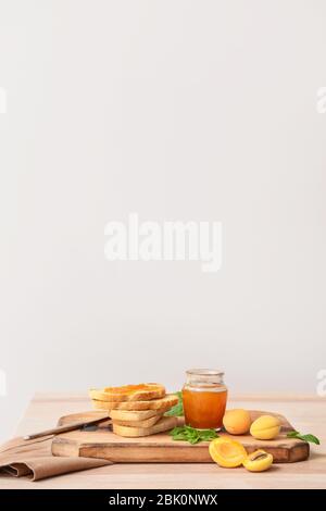 Pain grillé avec confiture d'abricot sur planche de bois Banque D'Images