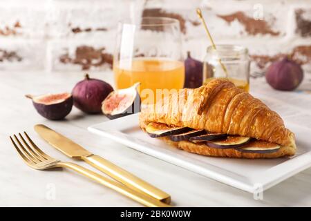 Plaque avec sweet croissant et de figue tranches sur le tableau Banque D'Images