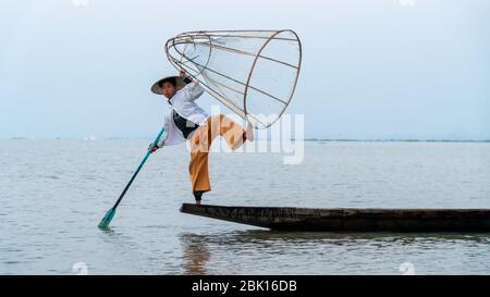 Nyaungshwe, Myanmar : 12 mars 2020 - pose de pêcheur pour une photo du lac Inle. Autrefois un pêcheur de tradition ancienne, maintenant faire de l'argent en posant pour des photos. Banque D'Images