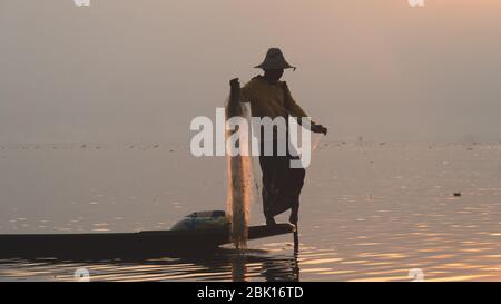 Nyaungshwe, Myanmar : 12 mars 2020 - poissons pêcheurs avec filet Inle Lake, deuxième plus grand, au lever du soleil. Silhouette à l'heure d'or près Banque D'Images