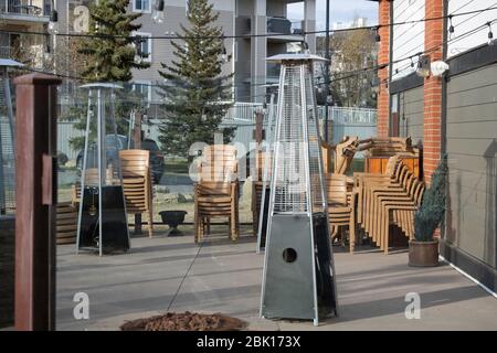 Chaises et tables empilées dans le patio extérieur - Restaurant fermé en raison de Covid- 19 Banque D'Images