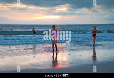 Portobello, Édimbourg, Écosse, Royaume-Uni. 1er mai 2020. Mai le premier plongeon du lever du soleil du mois pour Lorna, Gemma et Inga avec une température de 6 degrés et surtout nuageux. Prendre leur exercice quotidien autorisé et garder une distance sociale les uns des autres. Banque D'Images