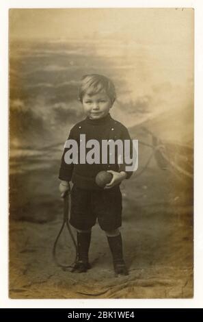 Carte postale de bord de mer du début des années 1900, jeune garçon tenant une chauve-souris et une balle, Eastbourne, Sussex, Angleterre, Royaume-Uni vers 1908 Banque D'Images