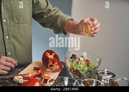 Homme préparant une salade de légumes saine pour le déjeuner Banque D'Images