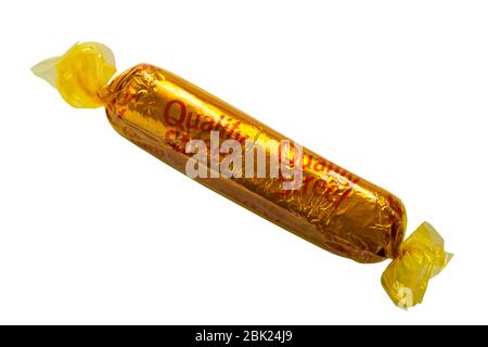 Rue de qualité par chocolat Caramel chocolat Nestle - doigt, Quality Street, jaune isolé sur fond blanc Banque D'Images