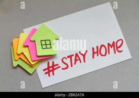 Plusieurs maisons en papier de plusieurs couleurs et hashtag restent à la maison. Concept Restez chez vous. Banque D'Images