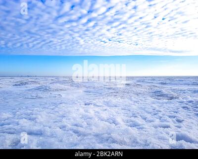 Paysage côtier d'hiver avec mer gelée, ciel bleu et de beaux nuages de fleurs. Champ de neige et ciel nuageux. Bannière Web. Banque D'Images