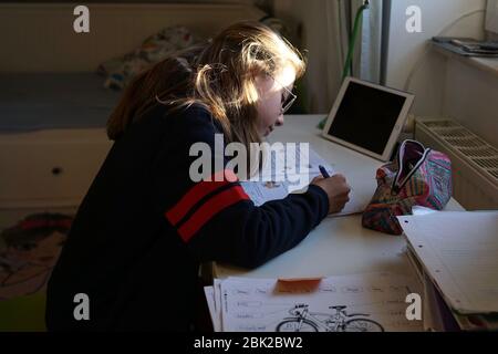 La vraie fille de 10 ans fait maison d'école, d'apprentissage à la maison, de faire des devoirs Banque D'Images