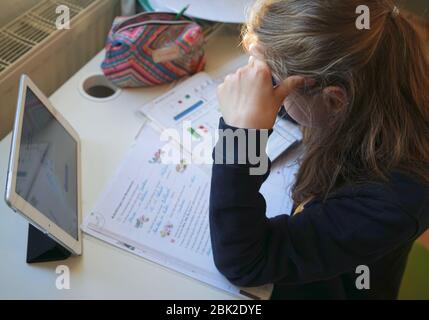 La vraie fille de 10 ans fait maison d'école, d'apprentissage à la maison, de faire des devoirs Banque D'Images