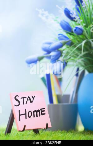 Note adhésive avec texte « Stay Home » au bureau vert Banque D'Images
