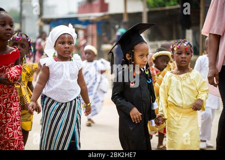 Abidjan, Côte d'Ivoire - 13 février 2018 : des enfants non identifiés vêtus de styles différents, marchent dans la rue lors d'une cérémonie festive d'enfants. Banque D'Images