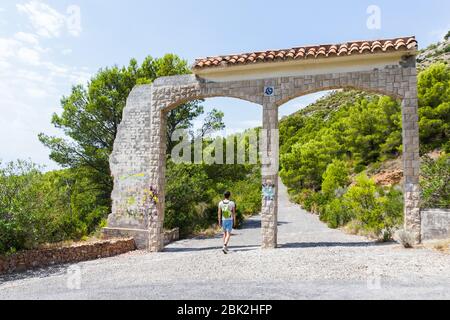 Belles ruines de pierre à Alcossebre, Espagne. Arches à gauche d'un bâtiment espagnol typique. Jour d'été ensoleillé. Un homme de derrière marche Banque D'Images