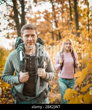 Deux Backpackers marchant à travers la forêt d'automne Banque D'Images