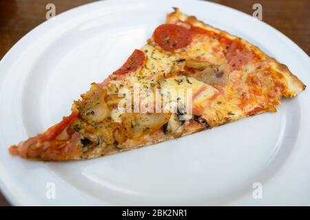Tranche de délicieuse pizza aux champignons pepperoni en croûte fine Banque D'Images