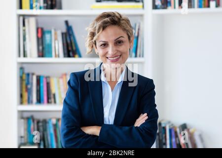Portrait de la femme d'affaires mûre en riant au bureau de l'entreprise Banque D'Images