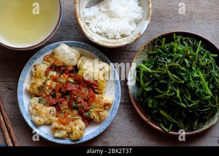 Repas végétalien vietnamien simple pour le déjeuner, épinards à l'eau bouillie, chou farci avec sauce tomate, bol de riz, nourriture saine qui riche en fibres Banque D'Images