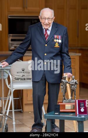 (200501) -- BEDFORDSHIRE, 1er mai 2020 (Xinhua) -- le vétéran britannique Tom Moore pose une photo avec la médaille et les cadeaux qu'il a reçus dans le Bedfordshire, Grande-Bretagne, le 30 avril 2020. Célébrant son 100ème anniversaire jeudi, le vétéran britannique Tom Moore a levé plus de 30 millions de livres (environ 37,8 millions de dollars américains) pour le National Health Service (NHS) en marchant sur son jardin. Crédit: Xinhua/Alay Live News Banque D'Images