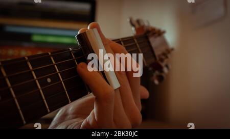 glissez sur le fingerboard de la guitare acoustique Banque D'Images