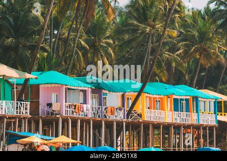 Canacona, Goa, Inde. Maisons d'hôtes peintes célèbres sur la plage de Palolem contre le fond des grands palmiers en Sunny Day. Banque D'Images