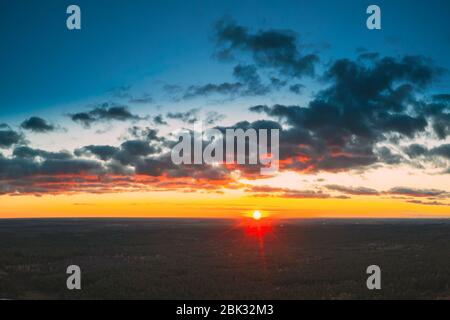 Vue aérienne du soleil dans le ciel spectaculaire lumineux de Sunrise. Ciel pittoresque et coloré à Dawn. Coucher de soleil au-dessus du paysage forestier en soirée. Vue de dessus de High Banque D'Images