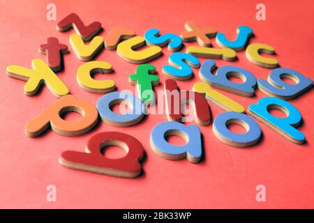 Alphabet anglais. Petites lettres anglaises en bois colorées sur fond rose. Banque D'Images