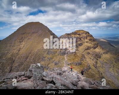 Marcheurs sur une crête promenade sur Beinn Alligin a munro (3000ft plus) montagne dans la région de Torridon de Wester Ross dans le nord-ouest des Highlands d'Écosse Banque D'Images