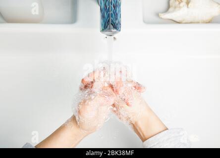 Enfant se laver les mains avec diligence avec du savon antibactérien et de l'eau en réalisant des mesures de protection de base contre la propagation du coronavirus COVID-19 deseas Banque D'Images