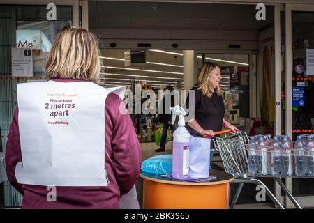 Le personnel du supermarché Sainsbury's en Angleterre, au Royaume-Uni, se tient à l'extérieur de l'entrée avec des produits de nettoyage et de désinfection pendant une pandémie de cavid Banque D'Images